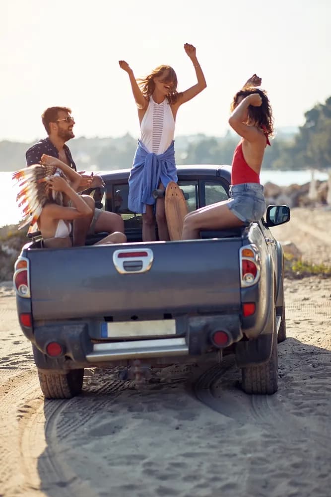 Amis en road trip, debout à l'arrière d'un pick-up