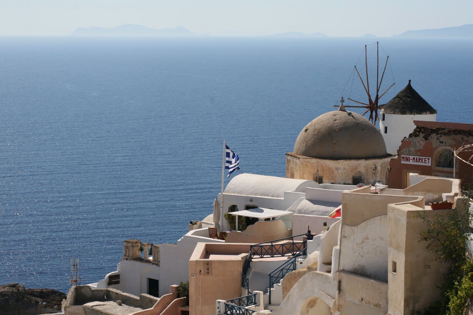 Église à dôme bleu et moulin d’Oia au-dessus de la mer, Santorin