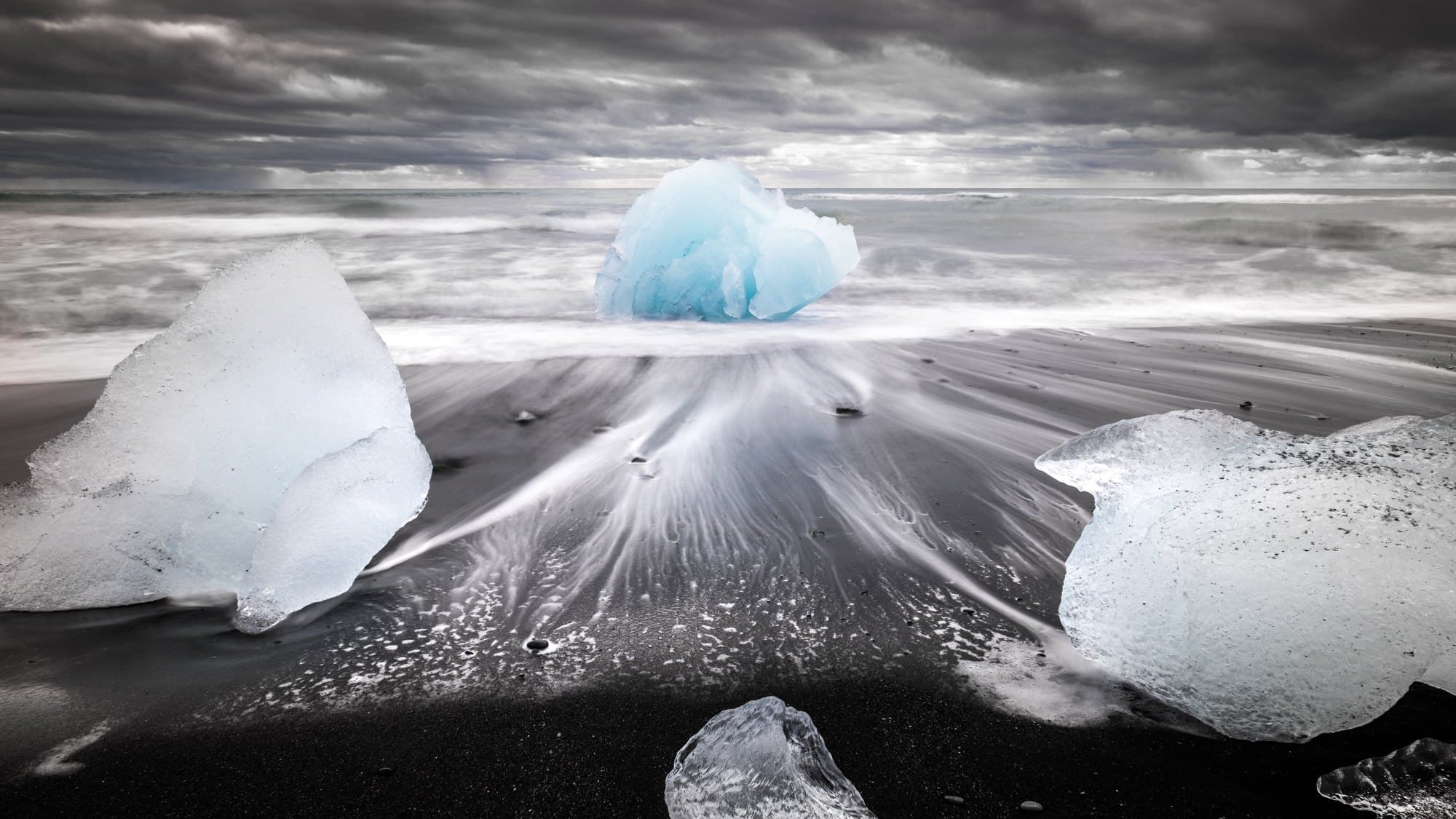 Blocs de glace sur le sable noir de Diamond Beach, les vagues en pose longue
