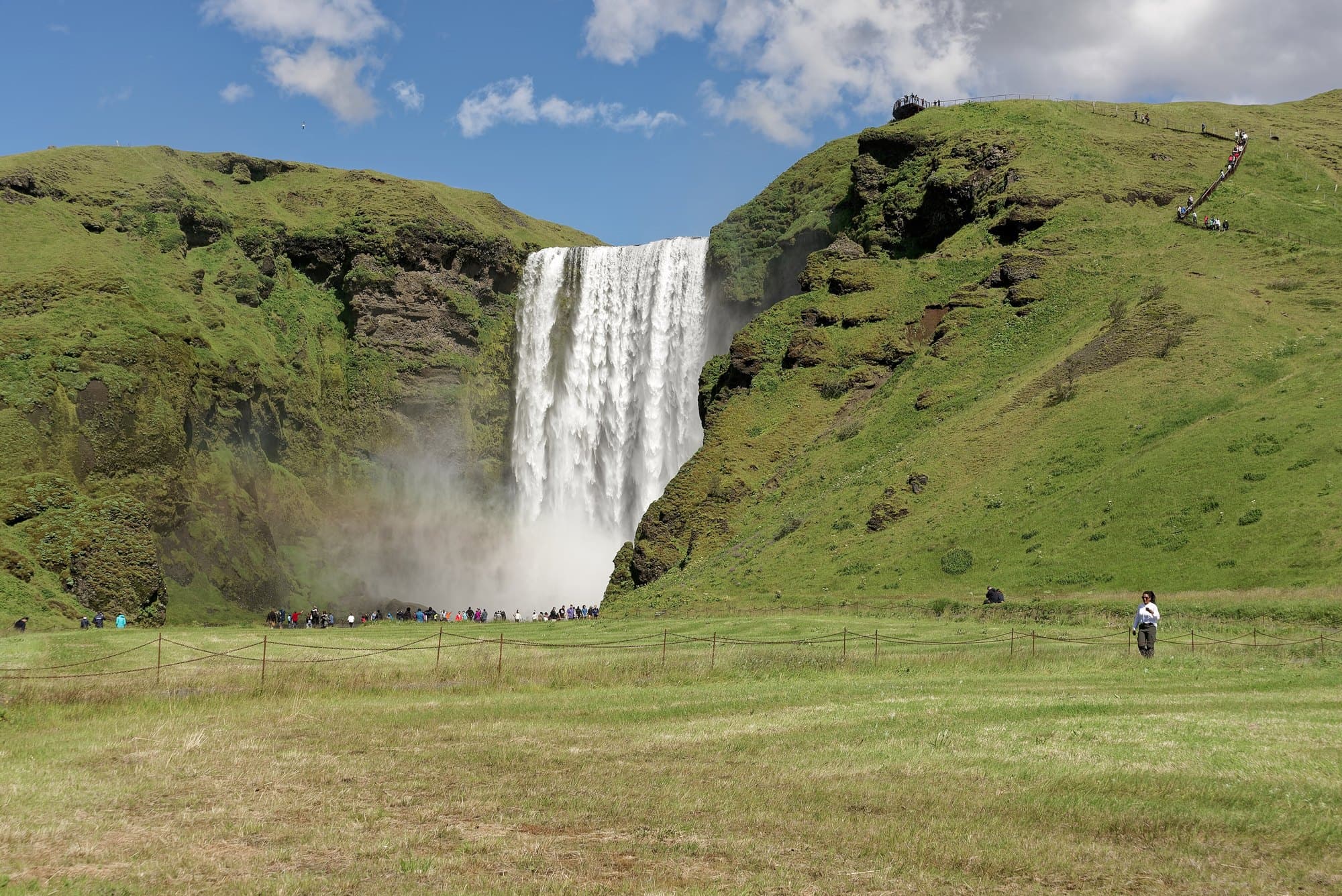 La cascade de Skógafoss entre deux versants verts